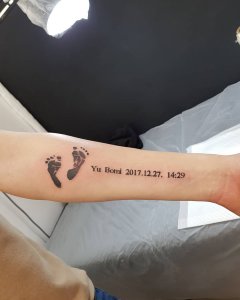 武汉于先生手臂上的儿子脚印和出生日期纹身图案